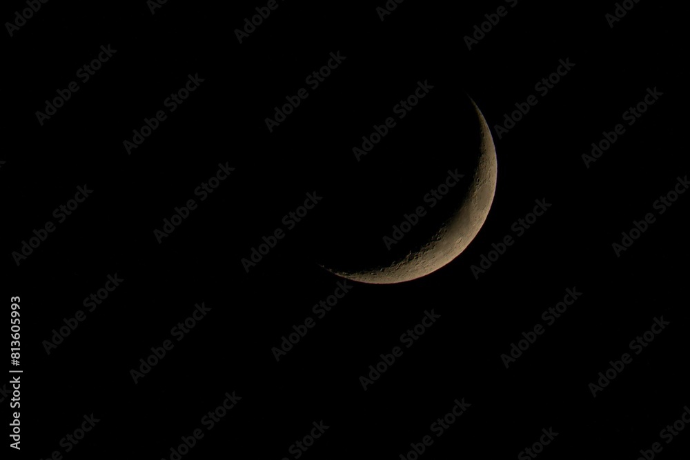 Waxing crescent phase of the moon on a dark sky background Waxing crescent phase of the moon on a dark sky background