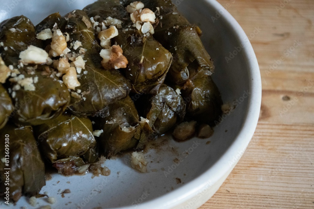 Dolma sprinkled with chopped walnuts in a white ceramic bowl Dolma sprinkled with chopped walnuts in a white ceramic bowl