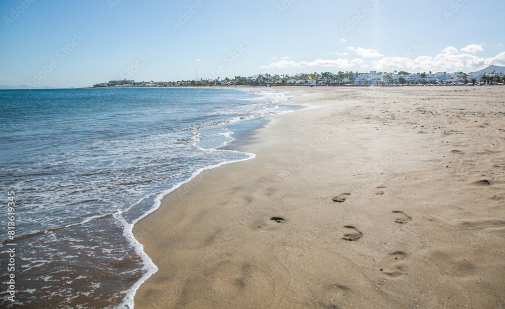 Lonely beach Playa de Los Pocillos with footprints in the sand, Lanzarote, Canary Islands, Spain
