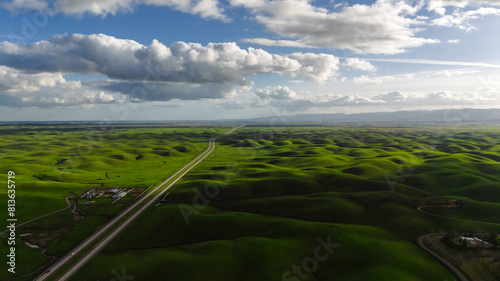 A breathtaking view of green hills against the sky from a height. Drone photo