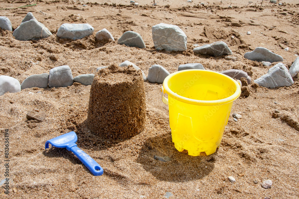 Bright plastic children's toys in the sand. Concept of beach recreation for children. Bright plastic children's toys in the sand. Concept of beach recreation for children.