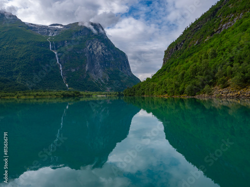 Imposing mountains and landscape, waterfalls reflection of the meltwater in the emerald green water in the Lovatnet, Lake Lodal valley, Loen, Norway photo