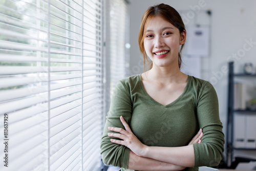 Young Asian business woman smiling confidently while standing alone in a bright modern office Free Download Young Asian business woman smiling confidently while standing alone in a bright modern office - GFXLoad