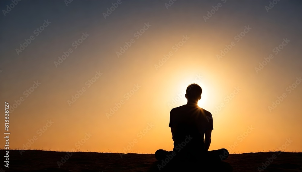 A man is seated in a lotus position with the sun in the background