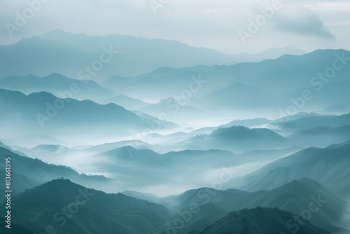 A tranquil view of the layers of mountain ridges disappearing into misty clouds, with their soft outlines and muted colors. © grey