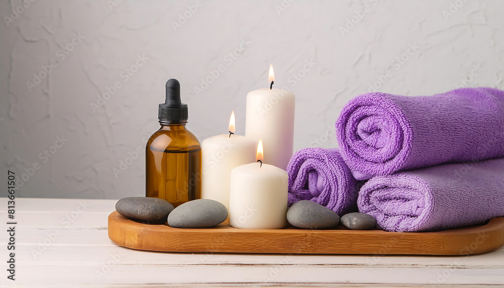 spa setting with white candles ,purple towels, oil and heat stones. spa treatments,