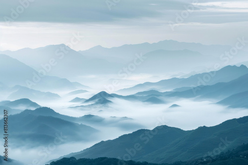 A tranquil view of the layers of mountain ridges disappearing into misty clouds, with their soft outlines and muted colors. © grey