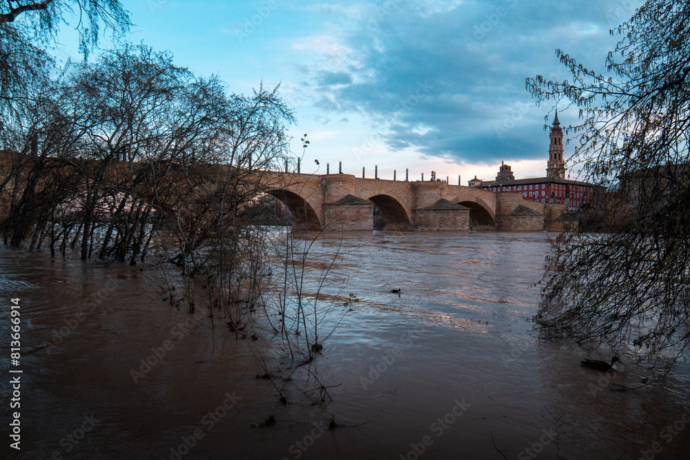 Obraz premium Misty Mornings: Capturing the Atmospheric Beauty of Zaragoza as Soft Clouds Blanket the Cityscape, Adding a Touch of Enigmatic Charm to the Urban Landscape.