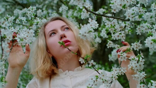 A beautiful blonde woman in a blossom tree branch watching the sky, a cosmetic advertisement theme
