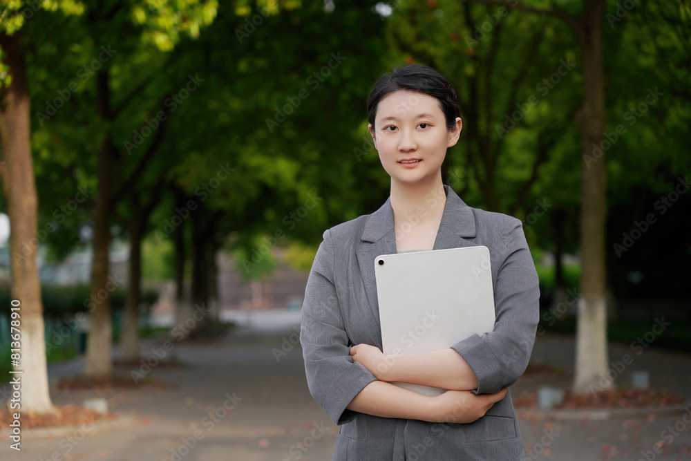 Fototapeta premium Confident Young Businesswoman with Tablet in Park