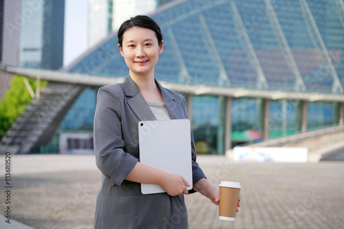 Confident Businesswoman with Tablet in Urban Setting © 昊 周