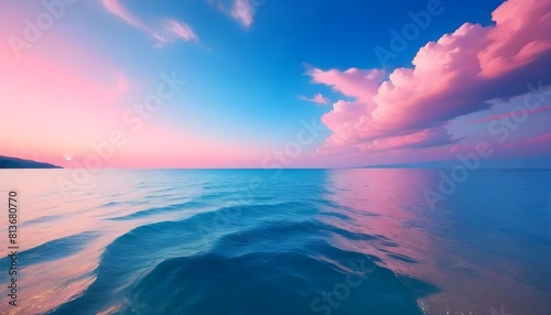 The sky displays a blend of pink and blue hues with clouds hovering above the vast ocean below