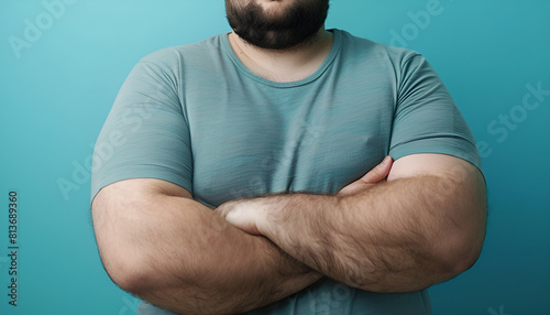 Overweight man in tight shirt on light blue background, closeup photo