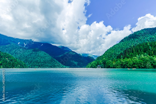 Lake Ritsa panoramic summer view. Beautiful summer nature landscape of Lake Ritsa in Abkhazia. Caucasus Mountains and Ritsa lake waters background wallpaper.