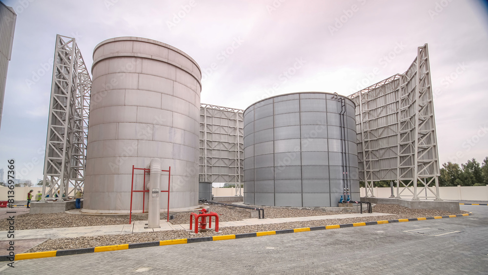 Obraz premium Two big silver Water Tanks with fence timelapse