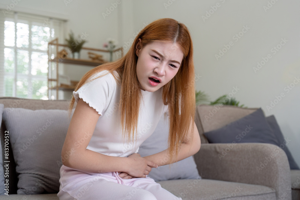 Asian woman having painful from stomach ache at home, Female suffering with abdominal pain Asian woman having painful from stomach ache at home, Female suffering with abdominal pain