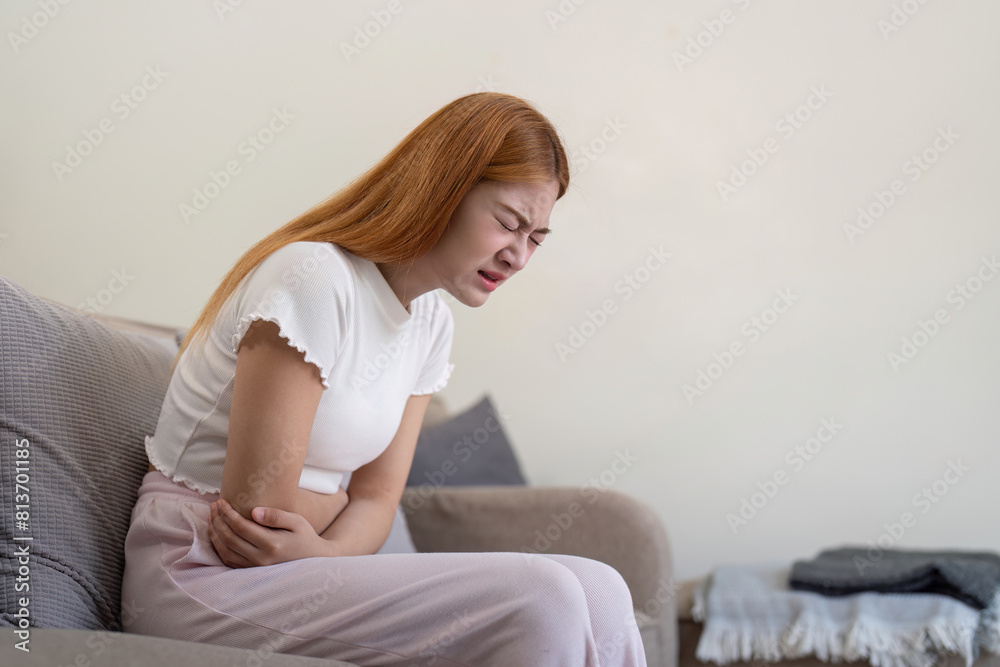 Asian woman having painful from stomach ache at home, Female suffering with abdominal pain Asian woman having painful from stomach ache at home, Female suffering with abdominal pain