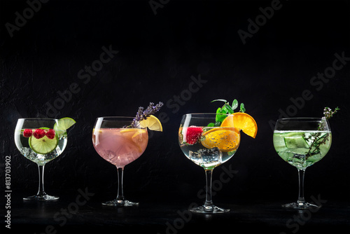 Fancy cocktails with fresh fruit. Gin and tonic drinks with ice at a party, on a black background, with copy space
