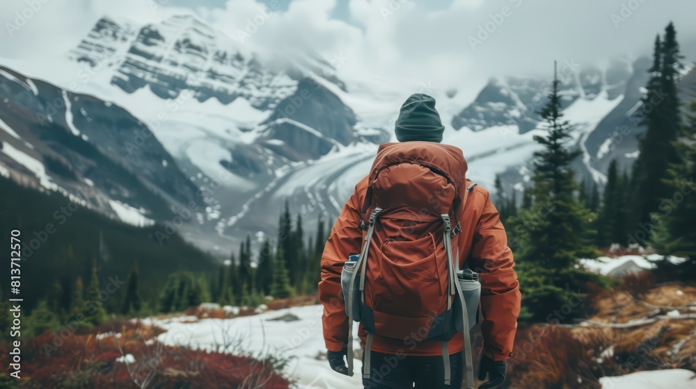 A solo adventurer backpacking through snow-capped mountains. A solo adventurer backpacking through snow-capped mountains.