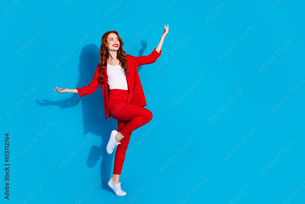 Full length photo of adorable gorgeous girl wear red trendy clothes dance empty space isolated on blue color background