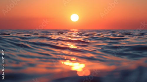 sun setting over the horizon  casting warm hues across a calm ocean. The close-up composition emphasizes the sun s reflection on the water