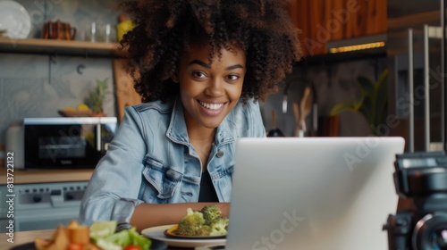 Smiling Woman with Computer in Kitchen photo