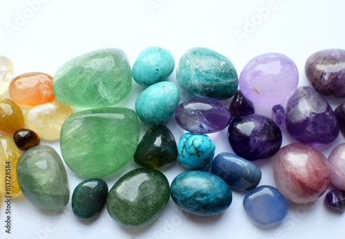 Multicolored healing chakra crystals. The stones are laid out in the shape of a rainbow. Real semi-precious stones: rose quartz, amethyst, citrine, agate, apatite, kyanite, fluorite.