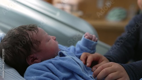 Heartwarming Sibling Interaction with Newborn in Hospital Room - Young boy gently tickles his baby brother standing by bedside, authentic real life family scene welcoming infant photo
