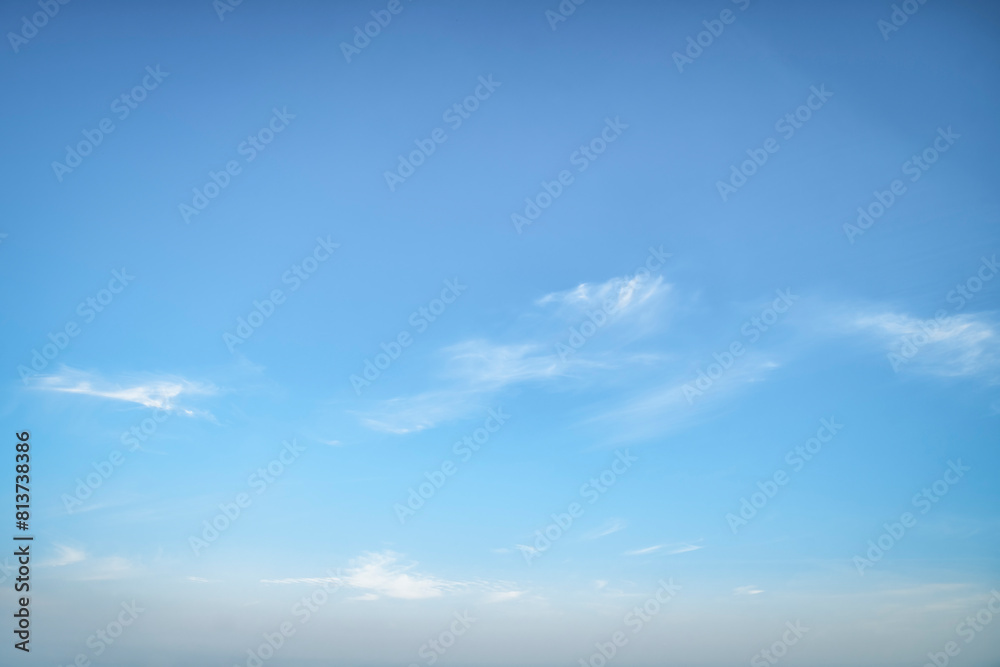 Obraz premium Clear blue sky. Light background with small white clouds.