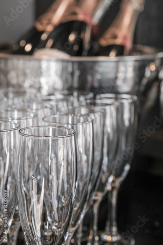 Many empty champagne glasses on blurred background of bottles