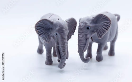 two plastic toy elephants on a white background