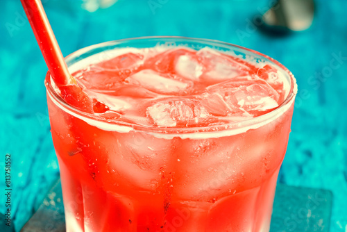 Summer refreshing red drink in a glass with a straw