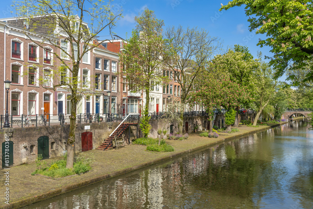 Oudegracht canal seen from a bridge. wooden stairs from the wharf to the street. traditional brick stone houses along the street with bicycles. Oudegracht canal seen from a bridge. wooden stairs from the wharf to the street. traditional brick stone houses along the street with bicycles.