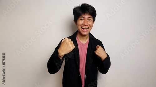 young asian man excited pose raising his hands photo