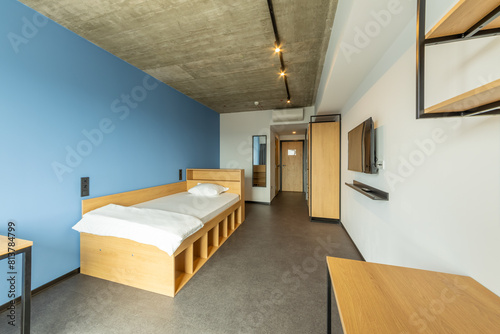 Simple student-style dorm bedroom. Hostel dormitory room. Campus photo