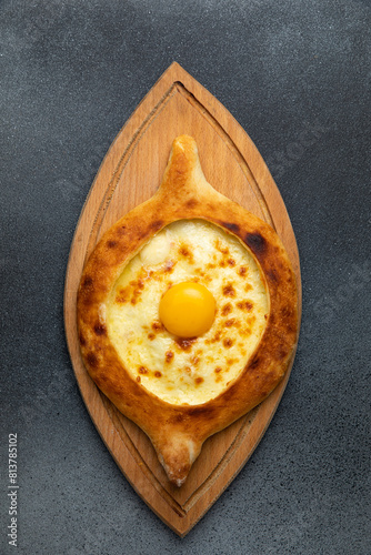 Georgian khachapuri with egg yolk on wooden board
