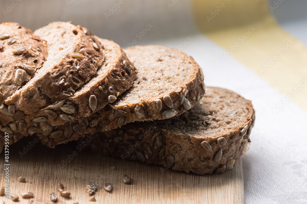 Whole grain bread with sunflower seeds on a wooden cutting board