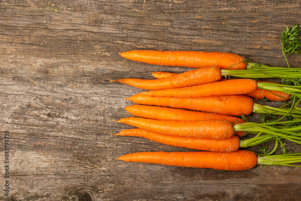 Carrots on a textured wooden background. Fresh and sweet organic carrots on a white background. Carrot slices. Vegan. Ingredients for salad. Place for text. Copy space. Flatley