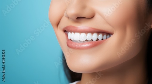 Close up of a beautiful young woman smiling with healthy white teeth on a blue background