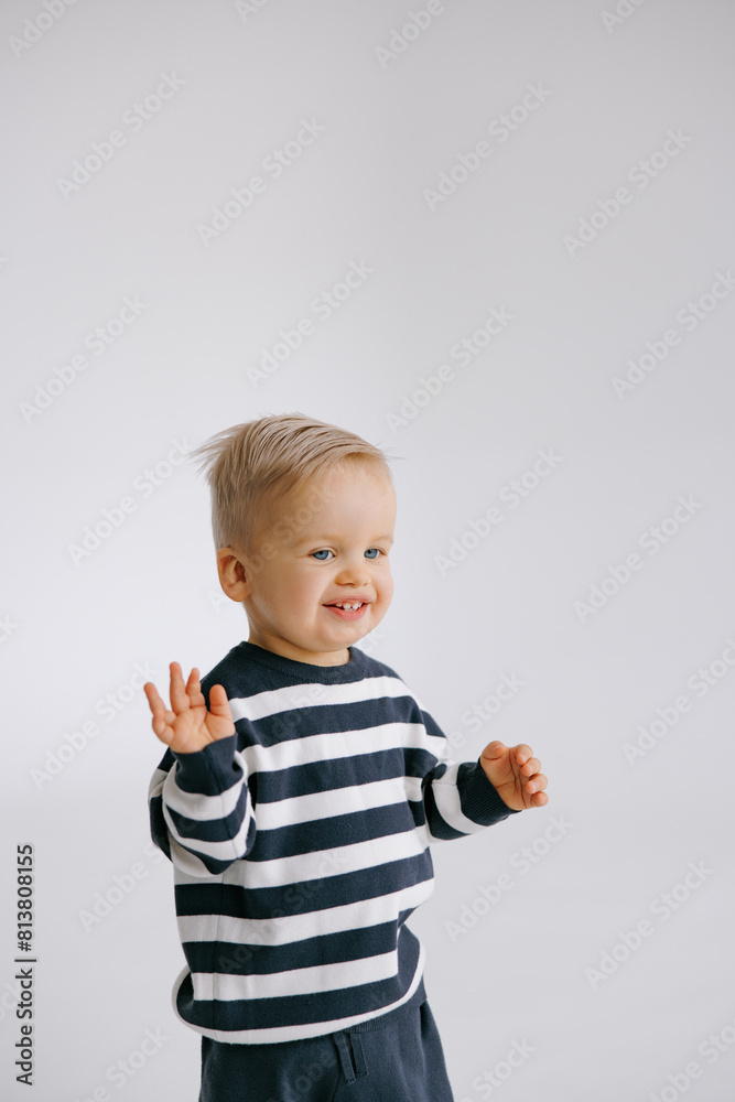 Cute smiling toddler boy standing in room against of white background. Cute smiling toddler boy standing in room against of white background.