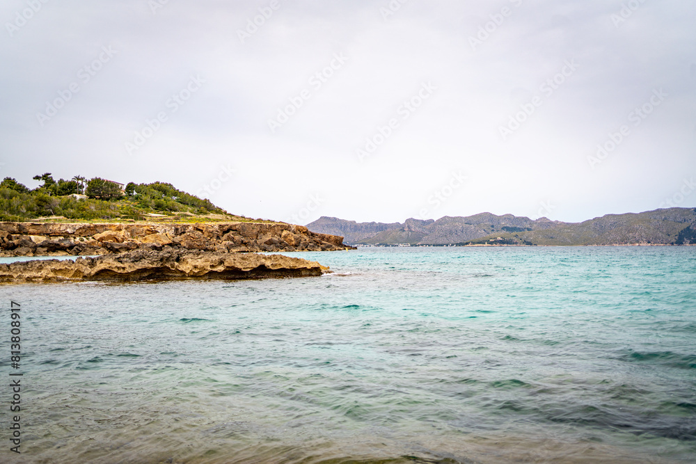 Fototapeta premium sea side shore in la victoria town in mallorca spain on a chilly day - blue waters and blue sky