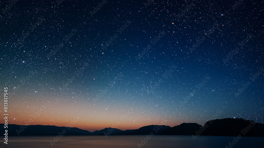 a movement of stars in the night sky with the view of mountains.