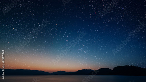 a movement of stars in the night sky with the view of mountains. © vovan