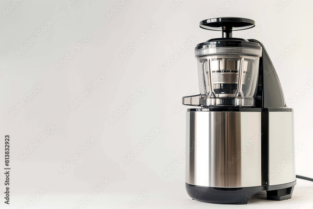 A professional-grade juicer with a heavy-duty motor and a durable stainless steel juicing screw isolated on a solid white background. A professional-grade juicer with a heavy-duty motor and a durable stainless steel juicing screw isolated on a solid white background.