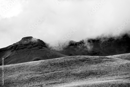 Clouds starting to flow over the mountains in the Drakensberg Mountain range in South Africa, in black and white photo