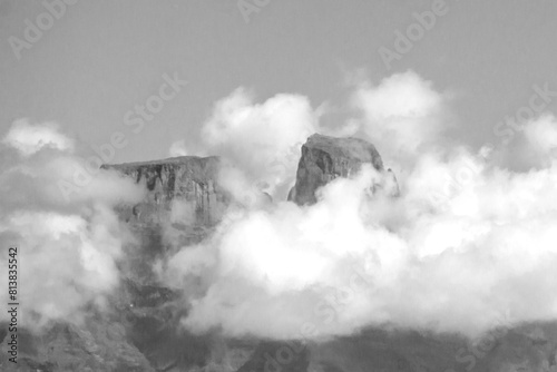The distant imposing basalt cliffs of the Drakensberg mountains peaking above the cloud cover