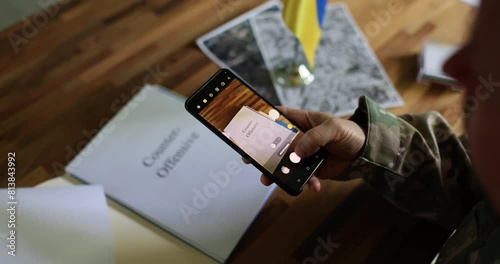Military photographs on phone a document with inscription top secret and counteroffensive war between Ukraine and Russia. Ukraine's counteroffensive, betrayal and military data leak photo
