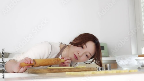 女性がめん棒で生地を伸ばすシーン