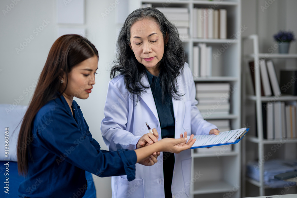 A woman in a blue shirt is being examined by a doctor A woman in a blue shirt is being examined by a doctor