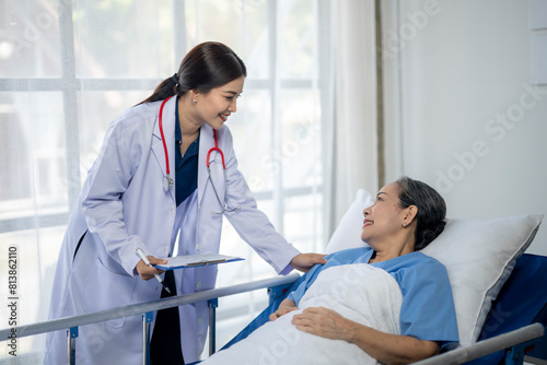 A woman in a white coat is talking to a woman in a hospital bed